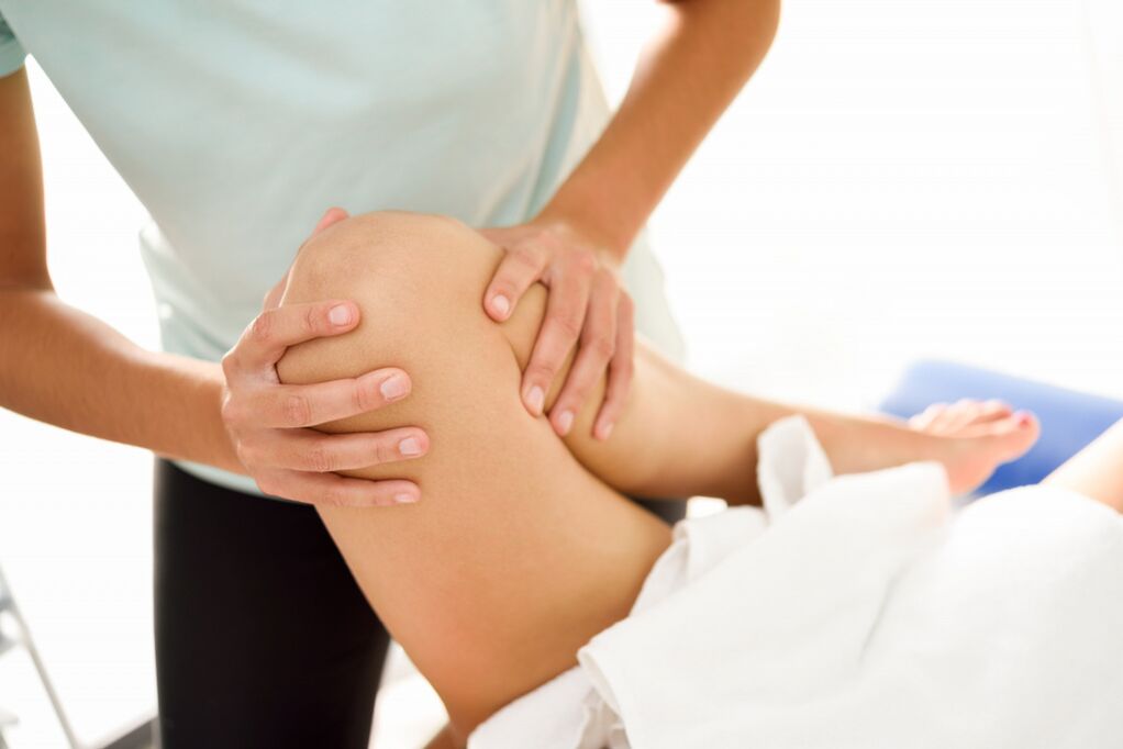 El especialista realiza el masaje terapéutico con artrosis de la rodilla